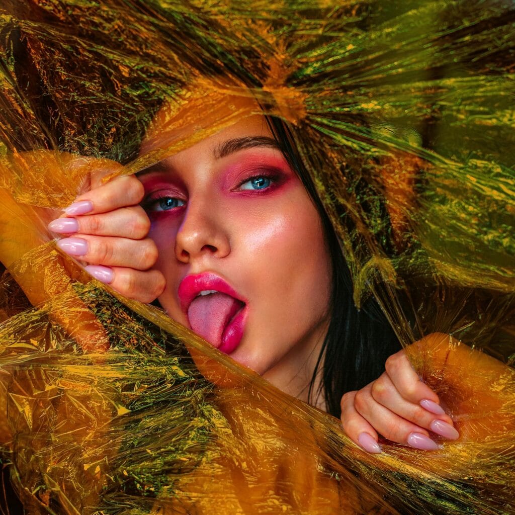 Model playfully showing colorful nail polish during a live cam stream.